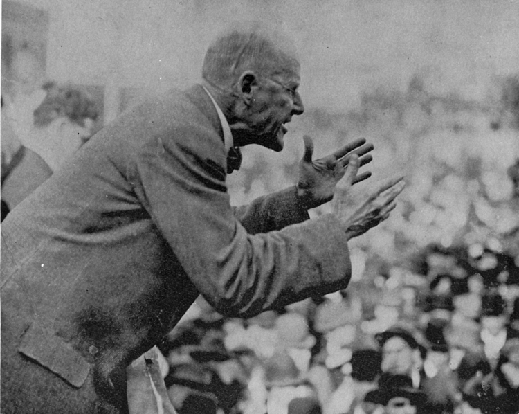 Eugene Debs giving a speech to a large crowd of workers.
